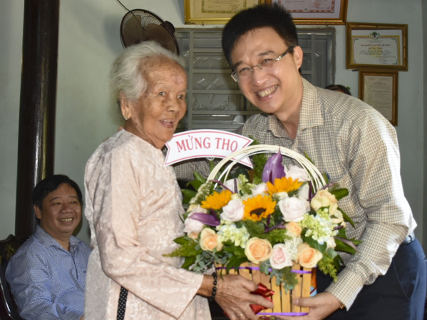 Đồng chí Đặng Minh Thông, Tỉnh ủy viên, Bí thư Thành ủy Bà Rịa tặng hoa mừng thọ Mẹ VNAH Trần Thị Đường (90 tuổi). 