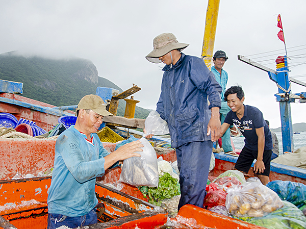 Ngư dân huyện Côn Đảo chuẩn bị lương thực, thực phẩm cho một chuyến ra khơi đánh bắt hải sản tại cảng Bến Đầm. Ảnh: MẠNH THẮNG