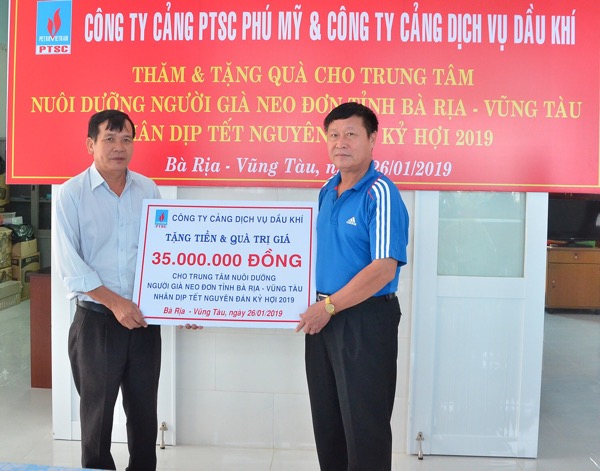 Ông Nguyễn Thế Chuyên, Chủ tịch Công đoàn Công ty Cảng dịch vụ dầu khí trao tấm bảng tượng trưng tiền và quà cho đại diện Trung tâm nuôi dưỡng người già neo đơn.