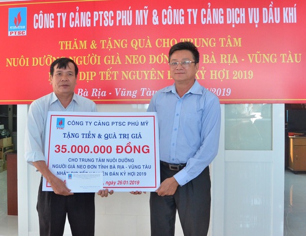 Ông Trần Đình Lâm, Chủ tịch Công đoàn Công ty Cảng PTSC Phú Mỹ trao tấm bảng tượng trưng tiền và quà cho đại diện Trung tâm nuôi dưỡng người già neo đơn.