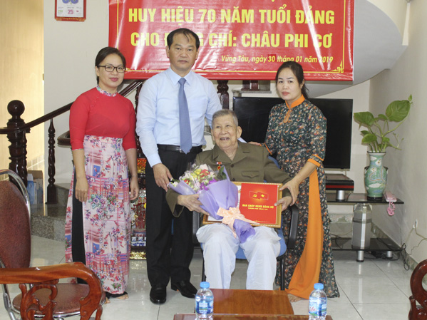 Đồng chí Mai Ngọc Thuận, Ủy viên Ban Thường vụ Tỉnh ủy, Bí thư Thành ủy Vũng Tàu, Chủ tịch HĐND thành phố trao Huy hiệu 70 năm tuổi Đảng cho đồng chí Châu Phi Cơ.