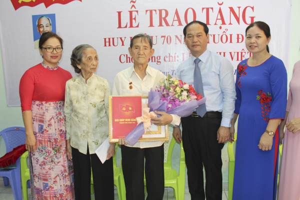 Đồng chí Mai Ngọc Thuận, Ủy viên Ban Thường vụ Tỉnh ủy, Bí thư Thành ủy Vũng Tàu, Chủ tịch HĐND thành phố trao Huy hiệu 70 năm tuổi Đảng cho đồng chí Lê Minh Việt.