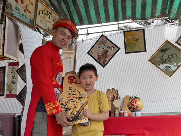 Trẻ em thích thú hụp hình cùng với “ông Đồ” Đăng Quang.