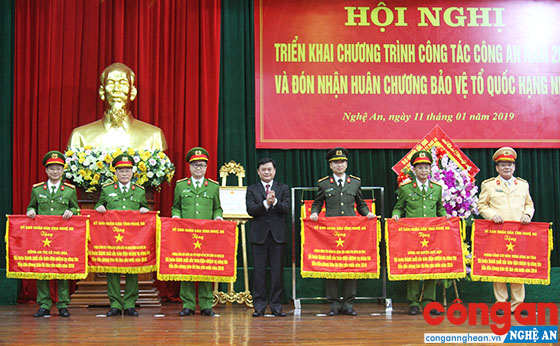 Thượng tá Đinh Anh Dũng, Trưởng Công an huyện Quỳ Hợp (thứ 2 từ phải sang) nhận Cờ đơn vị “Đã hoàn thành xuất sắc toàn diện nhiệm vụ công tác, dẫn đầu phong trào thi đua yêu nước năm 2018” của UBND tỉnh