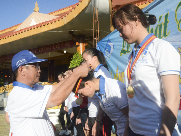 Đồng chí Tạ Văn Bửu, Chủ tịch UBND huyện Đất Đỏ trao kỷ niệm chương cho 10 VĐV nữ đi bộ đồng hành xuất sắc. 