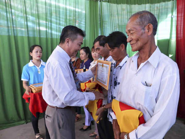 Ông Nguyễn Văn Triệu, Chủ tịch UBND xã Bình Châu (huyện Xuyên Mộc) trao Giấy khen và cờ Tổ quốc cho các ngư dân tiêu biểu trong phong trào bám biển, làm kinh tế giỏi năm 2018.