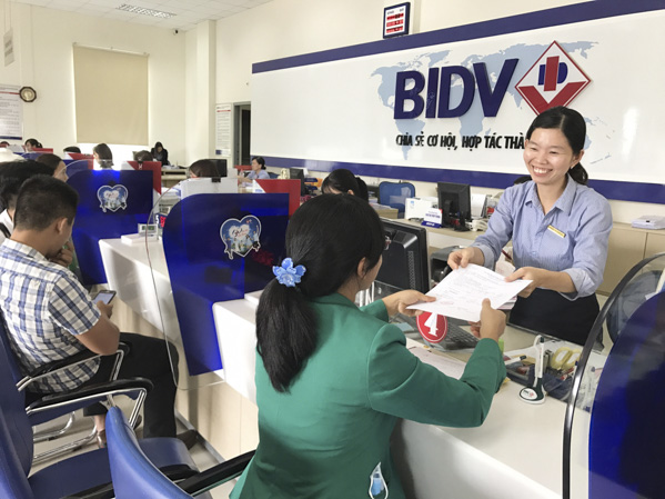 Gửi tiết kiệm được xem là kênh đầu tư an toàn. Trong ảnh: Khách hàng giao dịch tại BIDV Phú Mỹ.