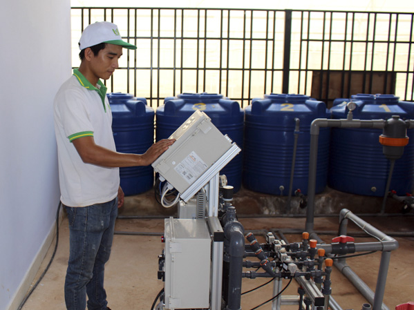 Công nhân điều khiển hệ thống tưới nước, bón phân tự động tại trang trai dưa lưới của Công ty UDEC, thị trấn Ngãi Giao, huyện Châu Đức.