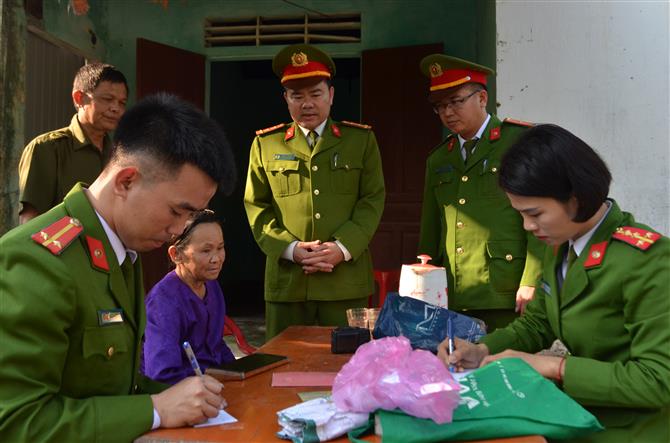 Bà Khắc Thị Lan (áo tím), 80 tuổi, sống một mình tại xóm 6A xã Thanh Phong, là hộ nghèo nhiều năm được tổ công tác của Công an huyện Thanh Chương ân cần thăm hỏi trong quá trình làm CMND