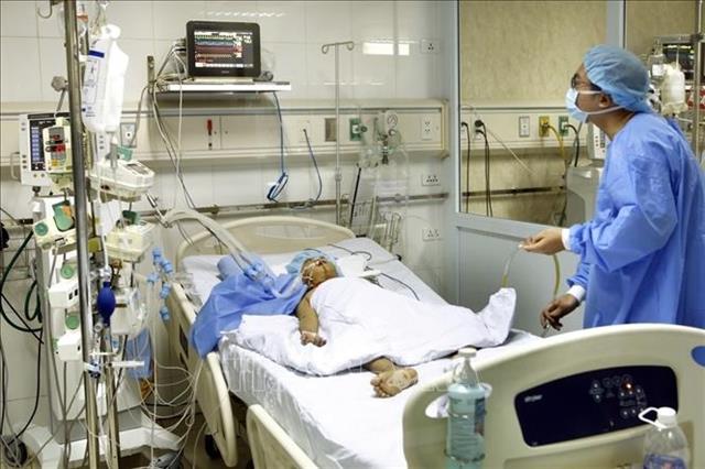 Cán bộ y tế chăm sóc bệnh nhi 9 tuổi sau ghép gan từ kỹ thuật chia gan. Ảnh: Dương Ngọc – TTXVN
