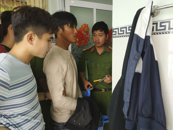 Lực lượng công an đưa đối tượng Nguyễn Văn Phú (đứng giữa) đến hiện trường vụ án để thực nghiệm điều tra.