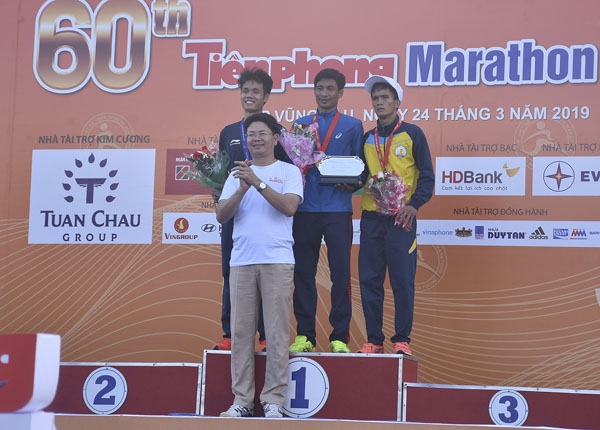 Đồng chí Nguyễn Thanh Tịnh, Phó Chủ tịch UBND tỉnh trao huy chương Vàng cho VĐV Nguyễn Văn Lai (đứng giữa) cự ly bán marathon 21km nam.