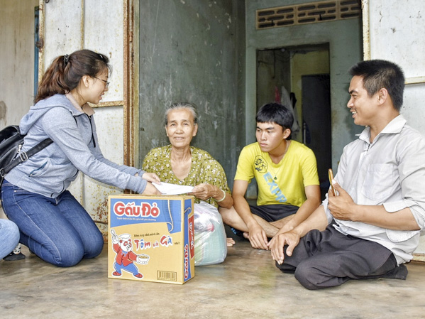 Anh Trần Văn Dương (bìa phải) và đại diện Công ty TNHH Nhà hàng EON 51 trao quà cho hộ dân có hoàn cảnh khó khăn ở xã Bàu Chinh (huyện Châu Đức). Ảnh: PHÚC LƯU 