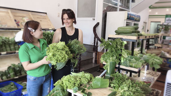 Bà Jade Tornquist, đến từ Australia thích thú khi mua rau được gói bằng lá chuối tại cửa hàng Vifarm.org.
