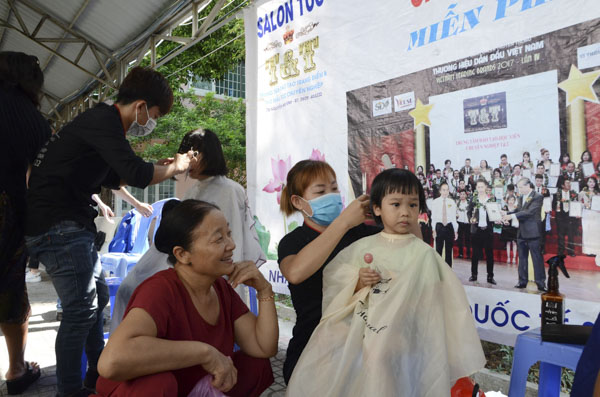Bà Thái Thị Miền đưa cháu ngoại Gia Hân đến cắt tóc miễn phí tại Bệnh viện Lê Lợi.