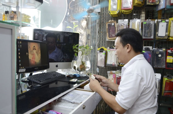Anh Võ Thái Sơn làm việc tại cửa hàng điện thoại. 