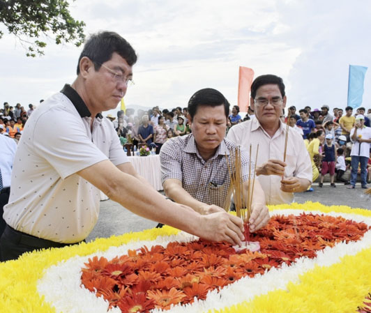 Đồng chí Trần Đình Khoa và đồng chí Nguyễn Văn Xinh và thắp hương tưởng niệm trên bè hoa.