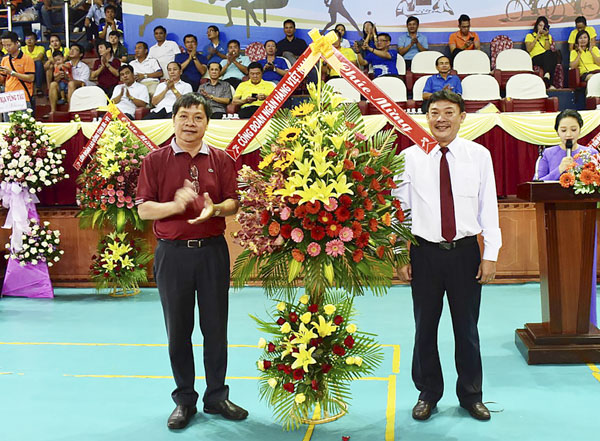 Ông Nguyễn Lợi, Giám đốc Ngân hàng Nhà nước tỉnh (bìa trái) tặng lẵng hoa chúc mừng cho đại diện Ban tổ chức hội thao.
