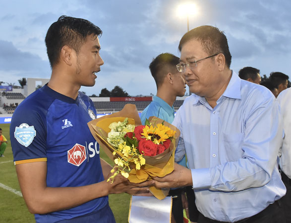 Đồng chí Nguyễn Văn Trình, Phó Bí thư Tỉnh ủy, Chủ tịch UBND tỉnh tặng hoa cho đội trưởng CLB BR-VT Hải Anh (23) trước trận đấu. 