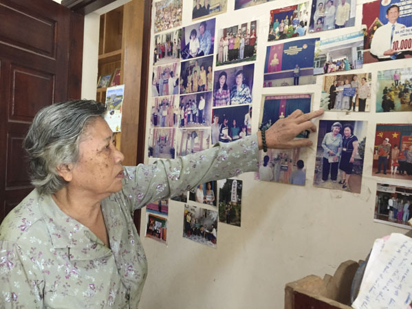 Bà Hồ Thị Kim Cẩn bên những tấm hình kỷ niệm mỗi khi tham gia các chương trình từ thiện xã hội trong nhiều năm qua.
