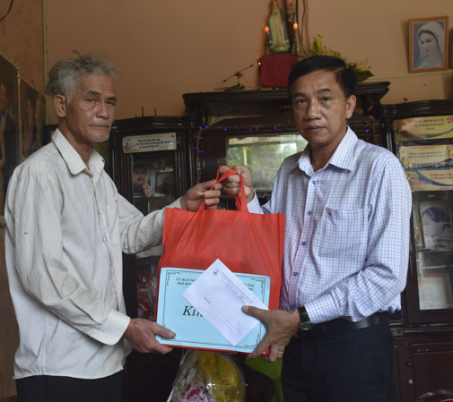 Ông Trần Quốc Khánh (phải) trao quà cho thân nhân anh Nguyễn Hà Thiên Thanh. 