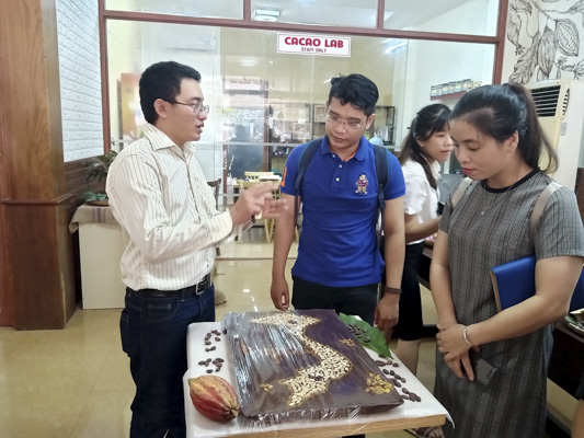 Ông Hồ Sĩ Bảo, Giám đốc Công ty TNHH Thực phẩm Amazon giới thiệu với khách tham quan về thanh chocolate khổng lồ.