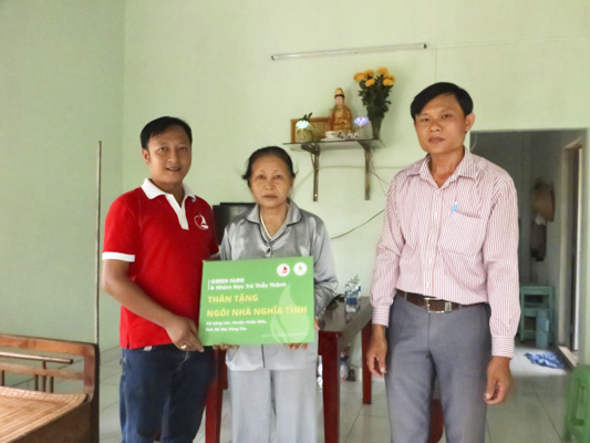 Ông Bùi Văn Thắng (bìa trái), Giám đốc Công ty TNHH TM DV 3T Plus trao nhà cho bà Nguyễn Thị Diên Hồng.