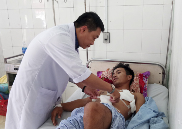 Bác sĩ Đàm Quang Tùng, Khoa Ngoại BV Lê Lợi kiểm tra vết thương cho bệnh nhân vừa được phẫu thuật cấp cứu thoát khỏi cơn nguy kịch.