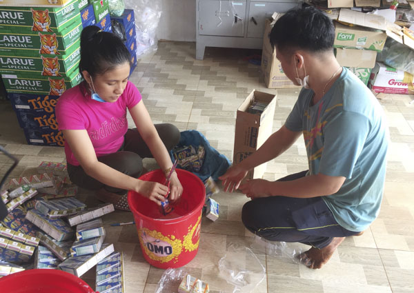 Nhân viên của hộ kinh doanh Đức Huy (Trung tâm mua sắm An Việt) ở xã Sơn Bình,  huyện Châu Đức tiêu hủy sữa tươi đã hết hạn sử dụng theo yêu cầu của đoàn kiểm tra. Ảnh: TƯỜNG NGÂN