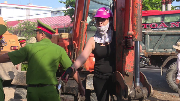 Đối tượng Trần Thị Nguyệt đứng trên gàu xúc lăng mạ thành viên Ban bảo vệ thi công.