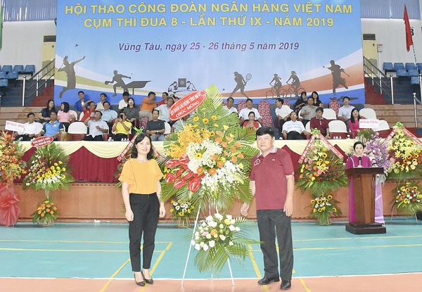 Bà Huỳnh Thị Phúc, Phó Chủ tịch Liên đoàn Lao động tỉnh (bìa trái) tặng hoa chúc mừng hội thao cho đại diện Ban Tổ chức hội thao.