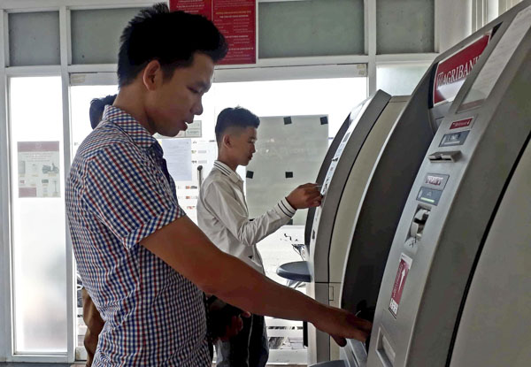 Theo lộ trình, đến cuối năm nay 30% lượng thẻ ATM sẽ được chuyển đổi thẻ từ sang thẻ chip.  Trong ảnh: Khách hàng rút tiền tại cây ATM của Agribank Vũng Tàu.
