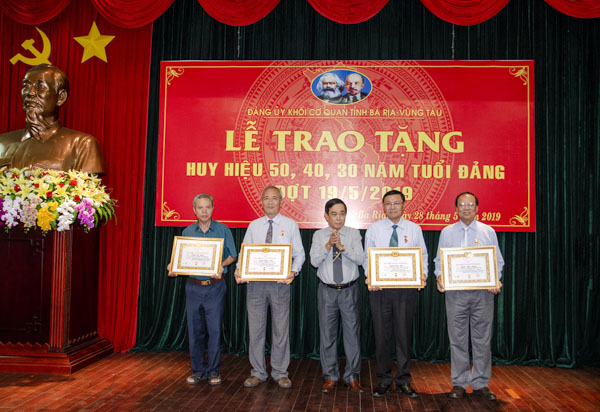 Đồng chí Đinh Văn Hùng, Bí thư Đảng ủy Khối Cơ quan tỉnh trao Huy hiệu 50 năm, 40 năm tuổi Đảng cho các đảng viên.