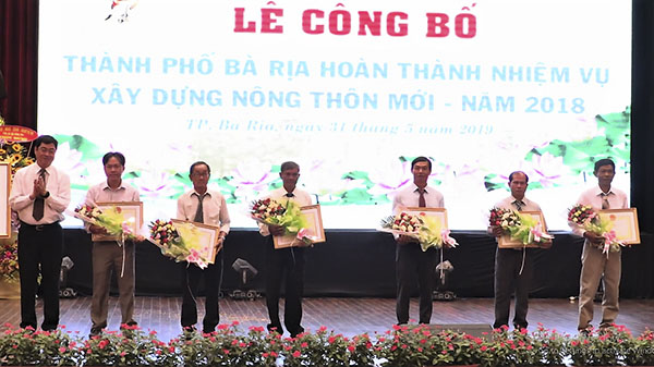 Đồng chí Trần Đình Khoa, Ủy viên Ban Thường vụ Tỉnh ủy, Phó Chủ tịch HĐND tỉnh khen thưởng cho 6 hộ gia đình đạt thành tích xuất sắc trong phong trào xây dựng nông thôn mới, giai đoạn 2011-2018.