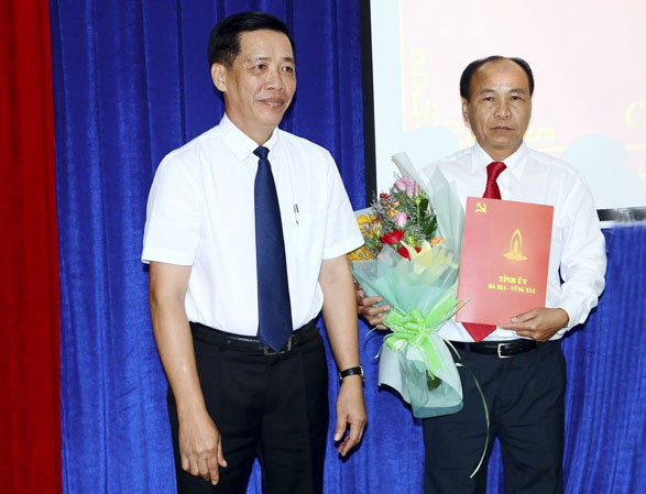 Đồng chí Lưu Tài Đoàn, Ủy viên Ban Thường vụ, Trưởng Ban Tổ chức Tỉnh ủy (trái) trao Quyết định và tặng hoa chúc mừng đồng chí Nguyễn Văn Việt.