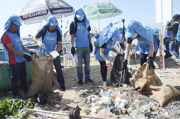 Nhân viên Công ty TNHH Nestle Việt Nam nhặt và phân loại rác trên bãi biển gần khu phố Lộc An, thị trấn Phước Hải sáng 8/6.