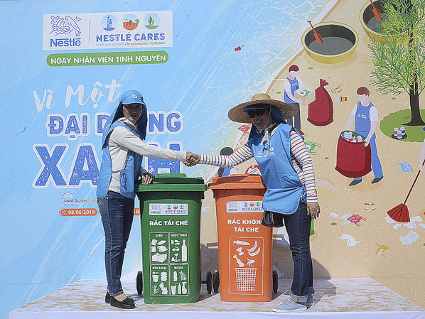 Đại diện Công ty TNHH Nestle Việt Nam (bên phải) trao tặng thùng rác cho thị trấn Phước Hải.