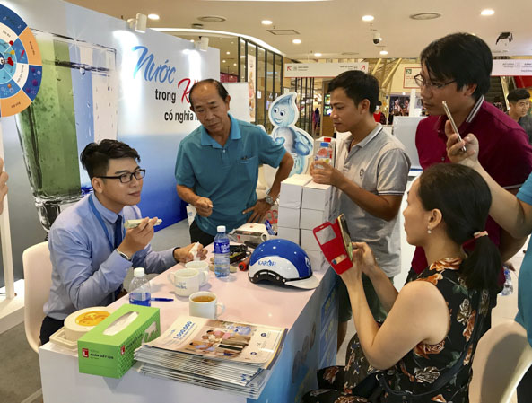 Nhân viên bán hàng Karofi thử nghiệm mẫu nước cho khách hàng tại quầy bán hàng máy lọc nước tại siêu thị Lotte Vũng Tàu.