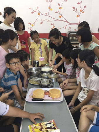 Cô Đào Thị Minh Uyên hướng dẫn các em nhỏ làm bánh trong lớp học bán trú tại Nhà thiếu nhi.