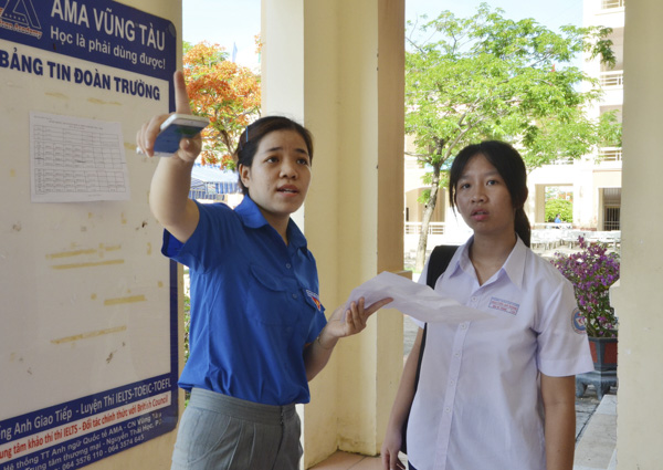 Cô Trần Trúc Quỳnh, GV Trường THPT Vũng Tàu hướng dẫn thí sinh nhận phòng thi. Ảnh: MINH THANH