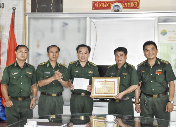 Đại tá Nguyễn Văn Tiến (thứ 2 từ trái qua), Phó Chỉ huy trưởng BĐBP tỉnh trao quyết định khen thưởng của Bộ Chỉ huy BĐBP tỉnh cho Đồn Biên phòng Phước Tỉnh. 