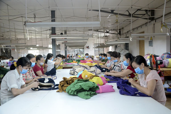 Công nhân Công ty TNHH May mặc Thăng Long kiểm tra các sản phẩm túi xách, vỏ gối xuất khẩu tại xưởng.