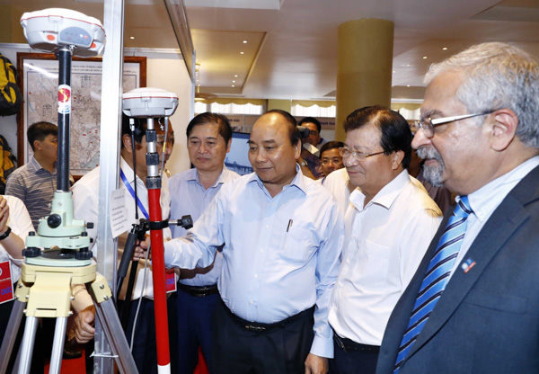 Thủ tướng Nguyễn Xuân Phúc và các đại biểu tham quan triển lãm công nghệ phòng chống thiên tai được trưng bày tại hội nghị. Ảnh: THỐNG NHẤT 