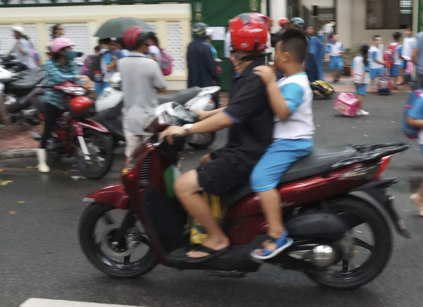 Một trường hợp người lớn đi xe máy có đội MBH cho mình, nhưng không đội MBH cho trẻ em chở theo phía sau.