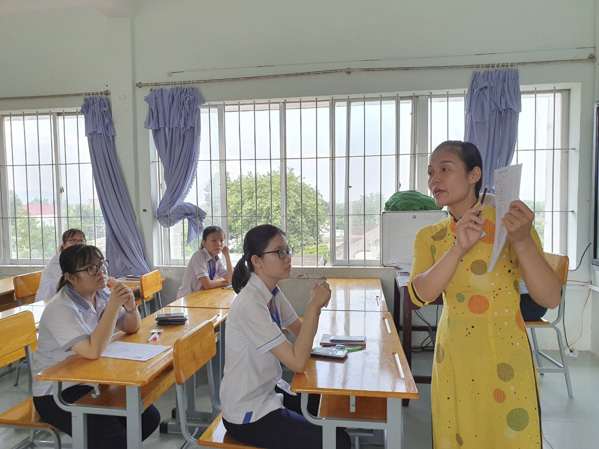 Cán bộ coi thi điểm thi THPT Trần Văn Quan (huyện Long Điền) hướng dẫn TS cách đánh chọn đáp án các bài thi trắc nghiệm môn KHTN. Ảnh: CẨM NHUNG