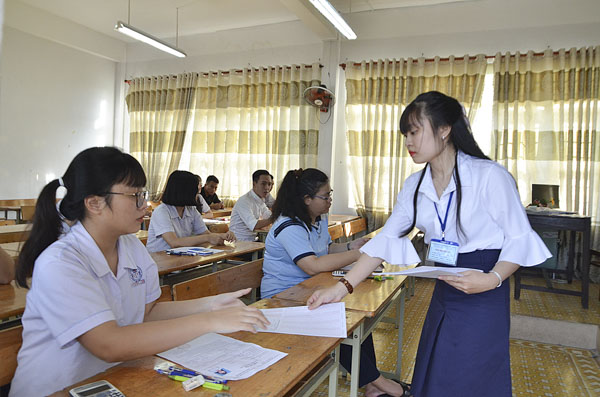 Cán bộ coi thi tại điểm thi Trường THPT Châu Thành, TP.Bà Rịa phát phiếu thi cho TS. Ảnh: MINH THANH