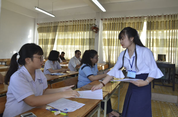 Cán bộ coi thi tại điểm thi Trường THPT Châu Thành, TP.Bà Rịa hướng dẫn TS điền thông tin. Ảnh: MINH THANH