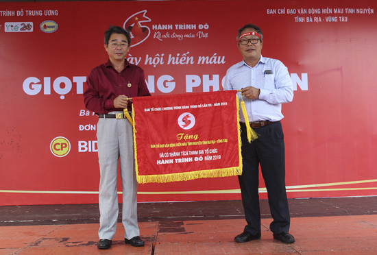 Tiến sĩ, Bác sĩ Lê Hoàng Oanh, Giám đốc Trung tâm Truyền máu Bệnh viện Chợ Rẫy tặng cờ lưu niệm của Ban Tổ chức Hành trình đỏ cho Ban Chỉ đạo vận động HMTN tỉnh.