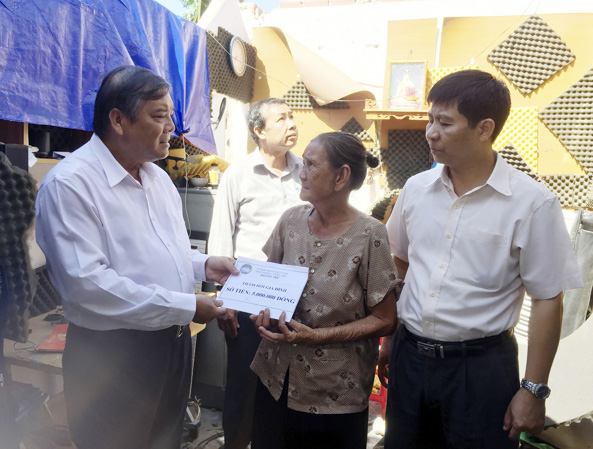 Ông Bùi Thanh Nghĩa, Ủy viên Ban Thường vụ Tỉnh ủy, Chủ tịch UBMTTQ Việt Nam tỉnh (bìa trái) thăm hỏi và hỗ trợ nạn nhân bị ảnh hưởng do cơn bão số 9 gây ra vào tháng 11/2018. Ảnh: TƯỜNG NGÂN