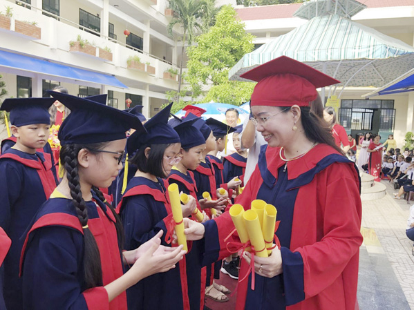 Cô Vũ Thị Việt Hoa trao chứng nhận hoàn thành chương trình Tiểu học cho HS lớp 5 niên khóa 2014 – 2019.
